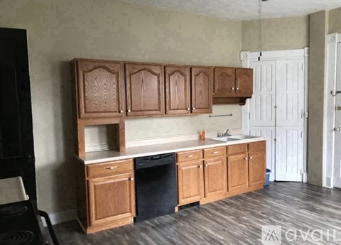 A kitchen with wooden cabinets and a black chair.