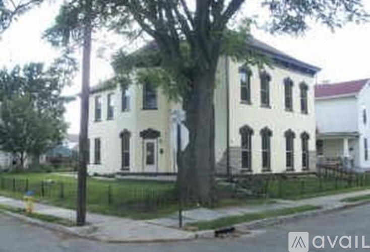 A white building with black trim and a black fence in front.