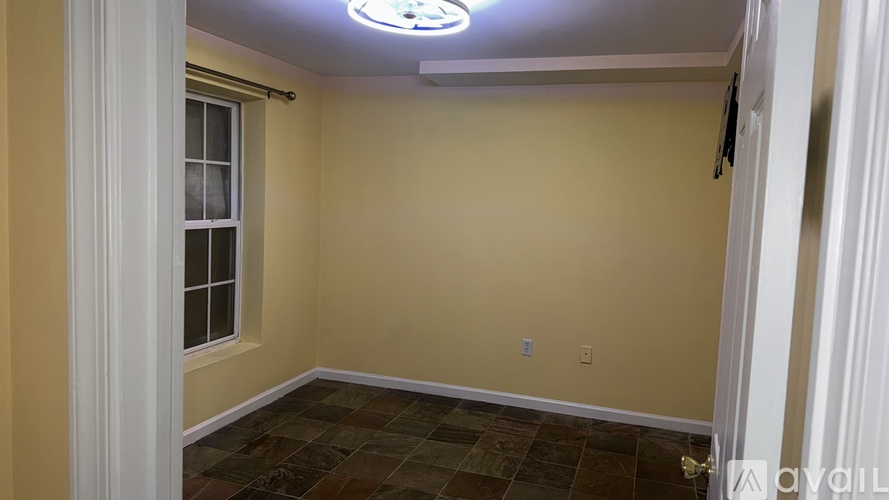 A room with a window and a tiled floor.