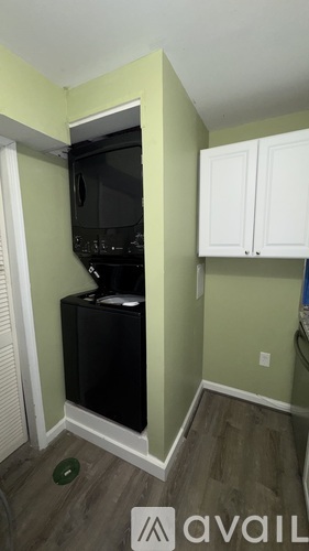 A black microwave and oven are built into a black cabinet in a kitchen.