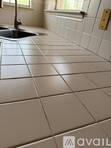 A kitchen with a sink and tiled floor.