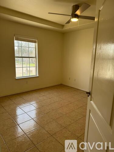 A room with a ceiling fan and a window.