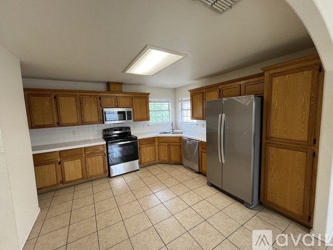 A kitchen with wooden cabinets and a refrigerator.