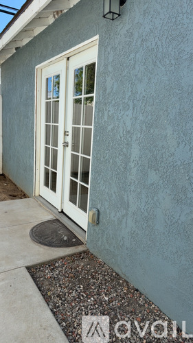 A white door with a glass window is on a blue wall.