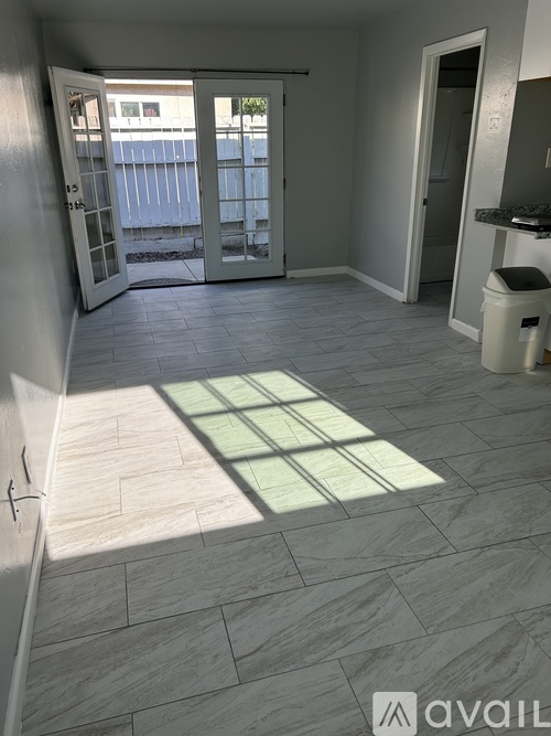 A room with a tiled floor and a door leading outside.