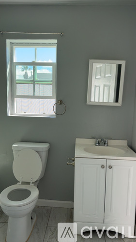 A white toilet and sink in a bathroom.