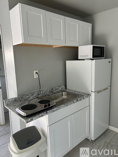 A kitchen with white cabinets and a granite countertop.