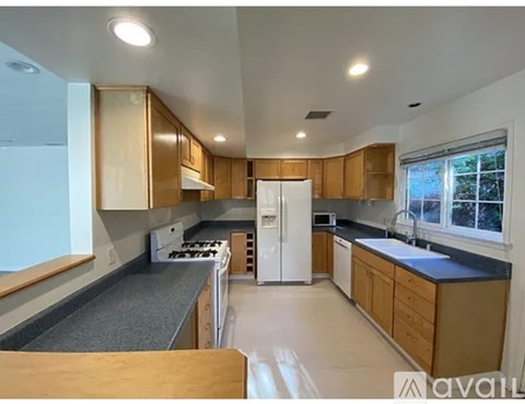 A kitchen with wooden cabinets and a white refrigerator.