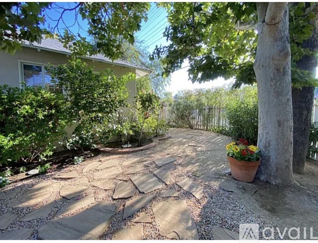 A stone pathway leads through a lush garden.