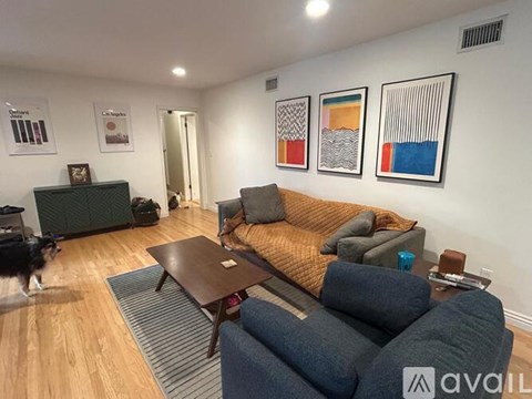 A living room with a couch, coffee table, and a dog.