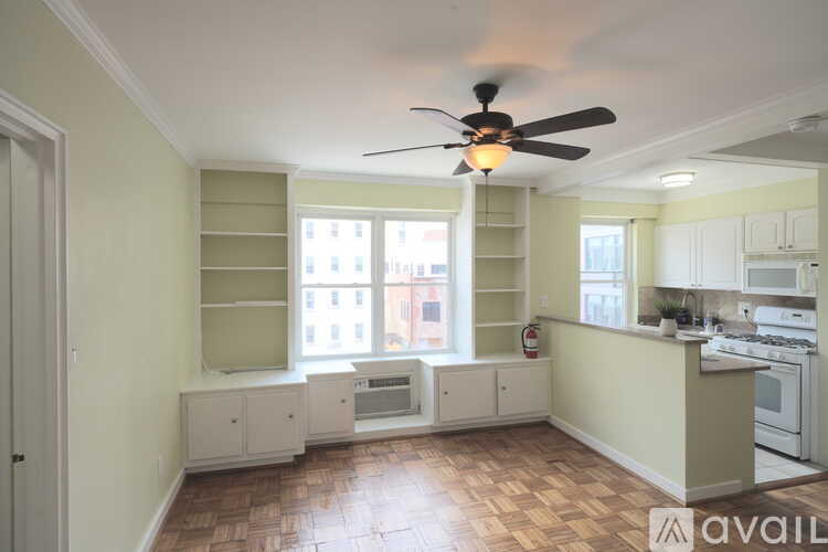 A kitchen with a fan and a window seat.