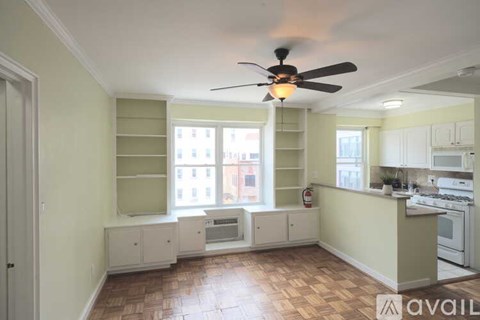 A kitchen with a fan and a window seat.
