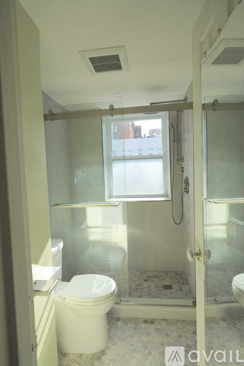A shower head and hand shower in a bathroom.