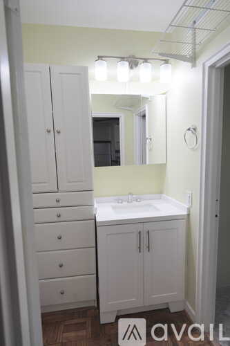 A bathroom with a sink, mirror, and cabinets.