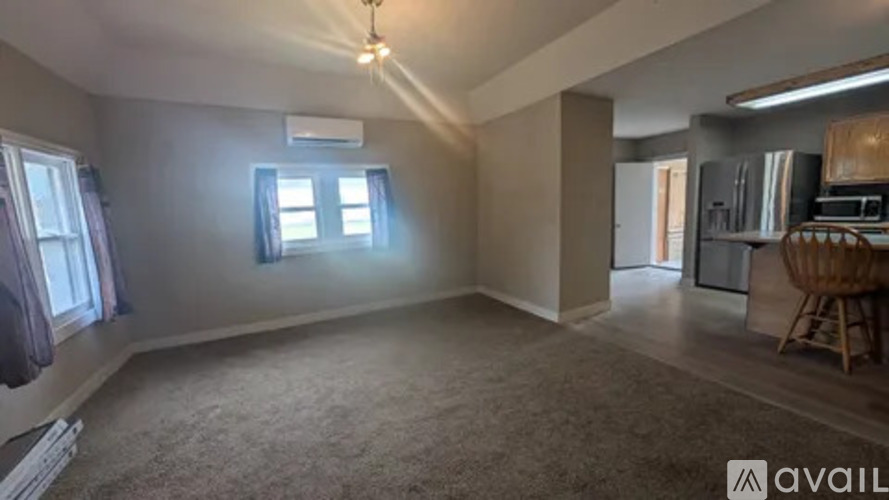 A room with a window and a carpeted floor.