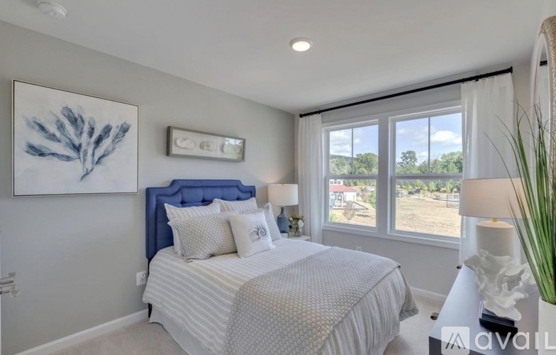 A bedroom with a large bed and a window overlooking a landscape.