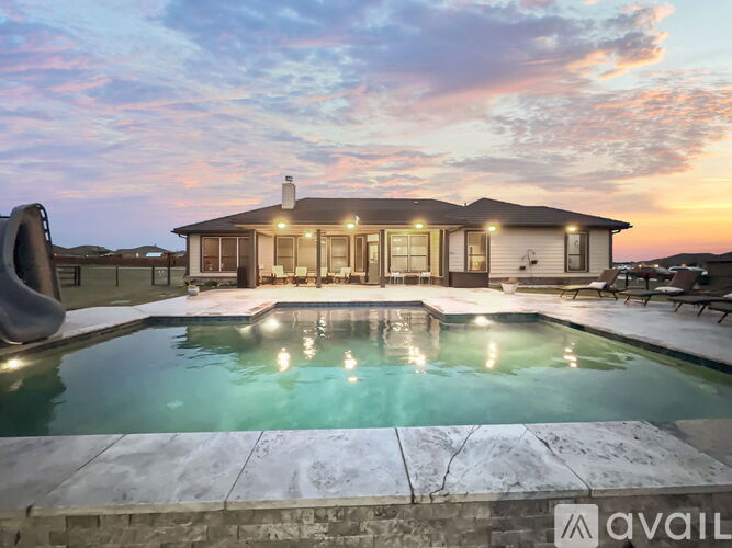A house with a pool in front of it is available for rent.
