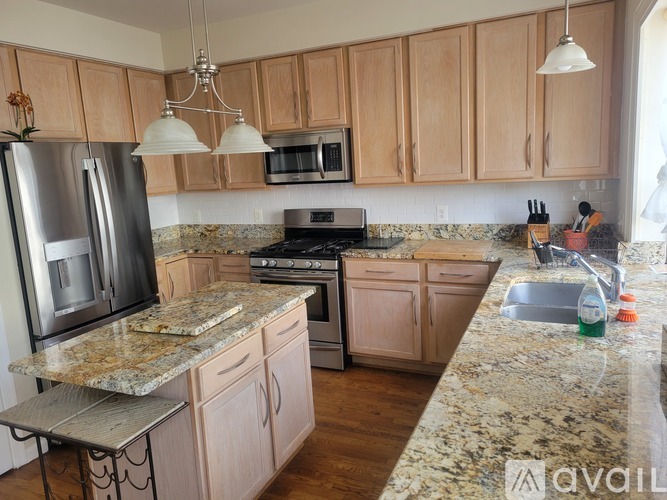 A kitchen with granite countertops and wooden cabinets.