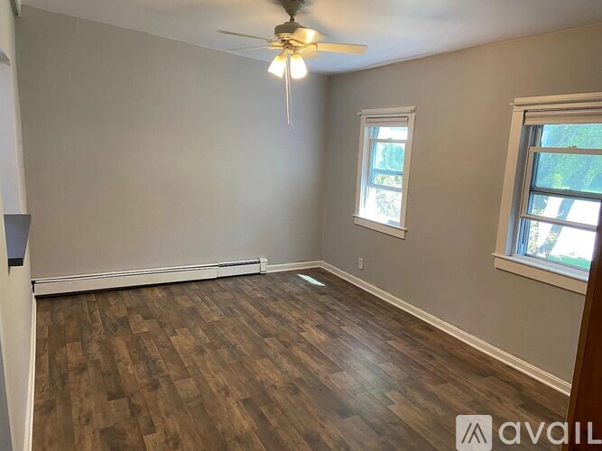 A room with wooden flooring and a ceiling fan.