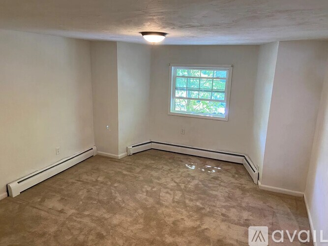 A room with a window and carpeted floor.