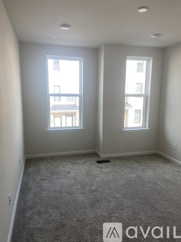 A room with two windows and a carpeted floor.
