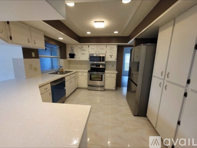A modern kitchen with white cabinets and appliances.