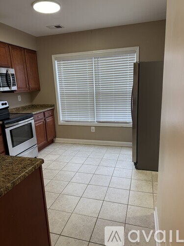 A kitchen with brown cabinets and a white stove top oven.