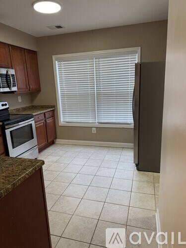 A kitchen with brown cabinets and a white stove top oven.