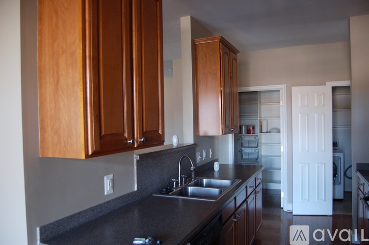 A kitchen with wooden cabinets and a black countertop.