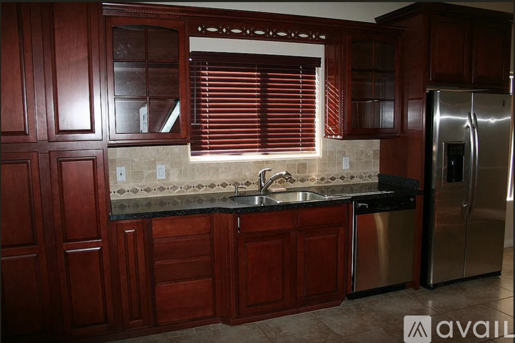 A kitchen with wooden cabinets and a stainless steel refrigerator.