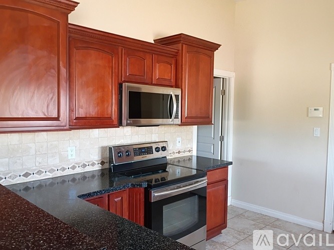 A kitchen with wooden cabinets and a black countertop.