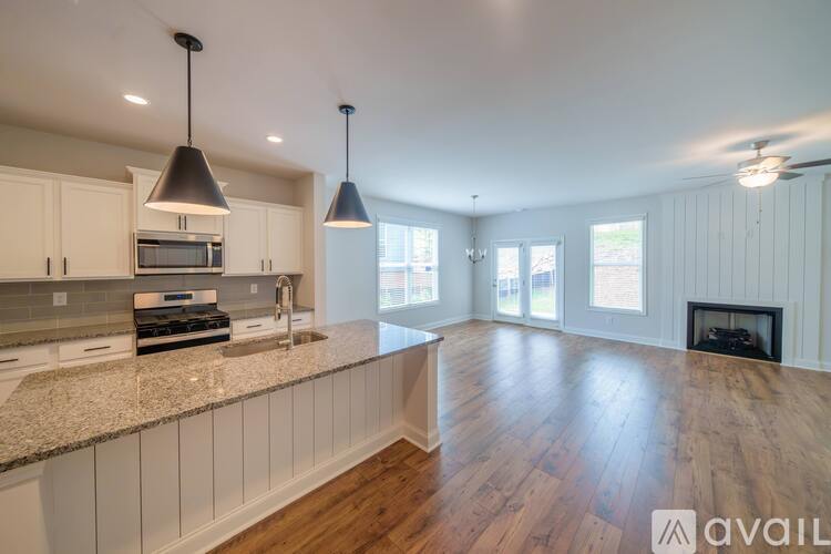 A kitchen with white cabinets and a wooden floor.