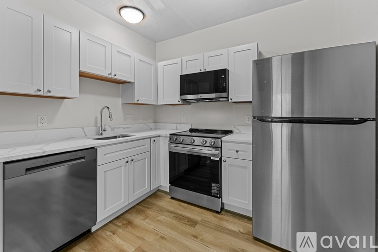 A modern kitchen with stainless steel appliances and white cabinets.