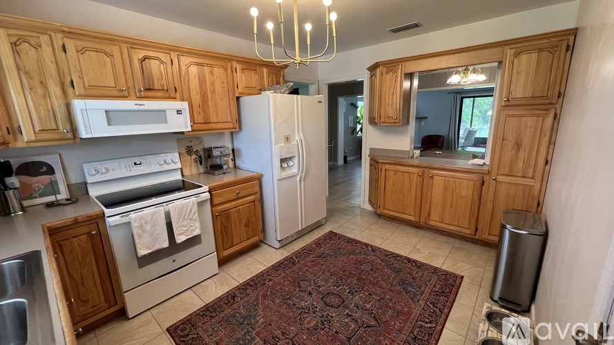 A kitchen with wooden cabinets and a rug on the floor.