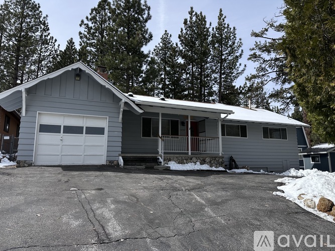 A house with a garage and a driveway in front of it.
