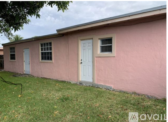A pink house with a white door and windows.