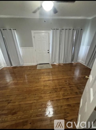 A room with wooden flooring and a white door.