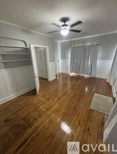 A room with wooden flooring and a ceiling fan.