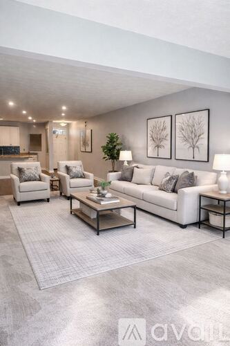 A modern living room with a grey carpet and white furniture.