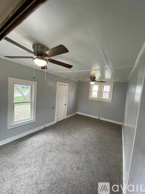 A room with a ceiling fan and carpeted floor.