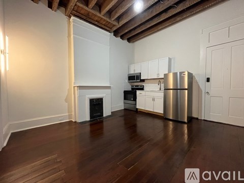 A kitchen with white cabinets and a stainless steel refrigerator.