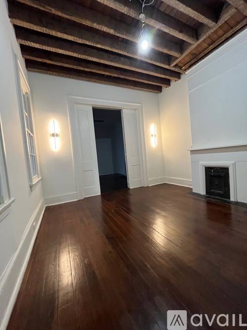 A room with wooden floors and a fireplace.