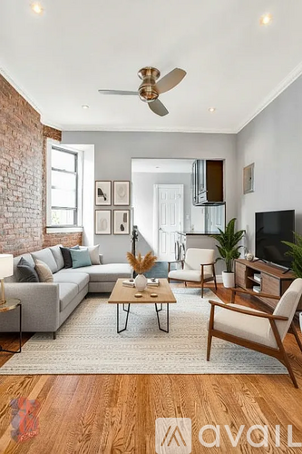 A living room with a grey couch, a wooden coffee table, and a television.
