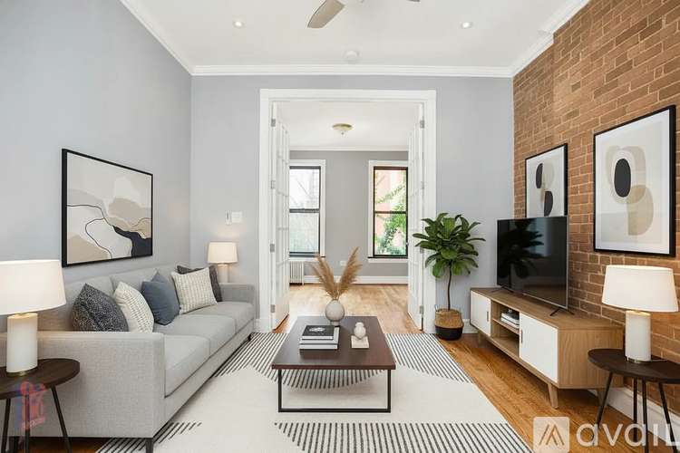 A living room with a grey couch, a coffee table, and a television.