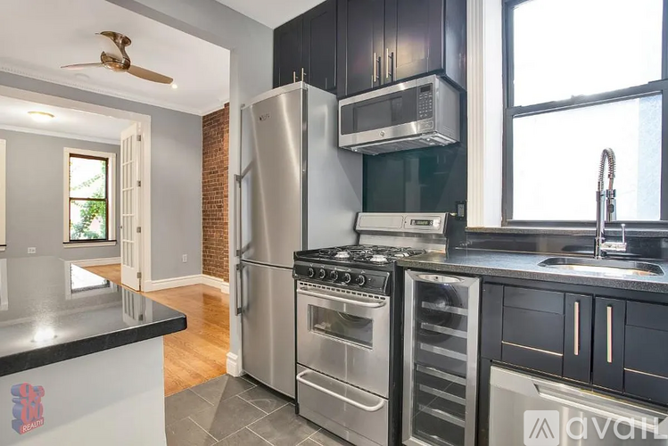 A modern kitchen with stainless steel appliances and black cabinets.