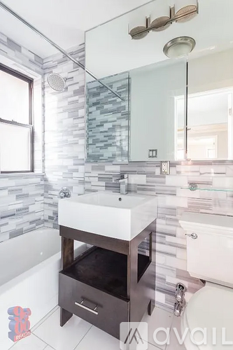 A modern bathroom with a white sink and a glass shower.
