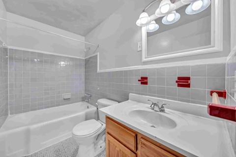 A white bathroom with a white toilet, white sink, and a white bathtub.
