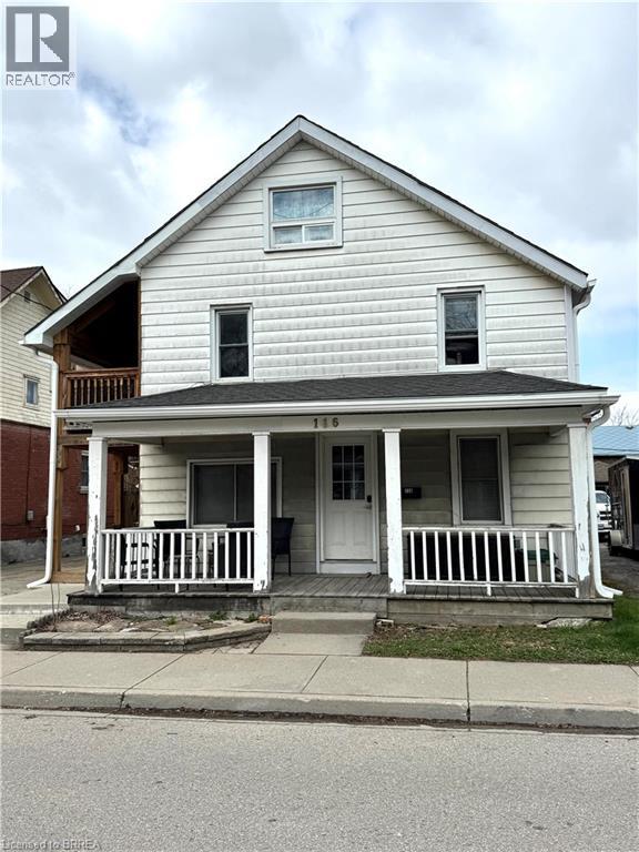 A two-story house with a porch and a balcony on the second floor.