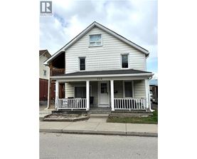 A two-story house with a porch and a balcony on the second floor.