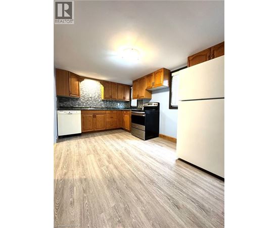 A kitchen with wooden cabinets and a white refrigerator.
